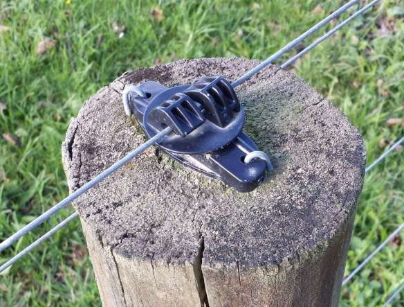 Electric wire on top of fence post